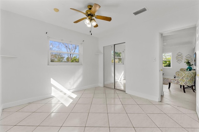 unfurnished bedroom with ceiling fan, a closet, and light tile patterned floors