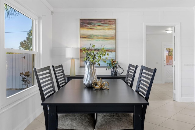 dining space featuring tile walls, light tile patterned floors, and ornamental molding