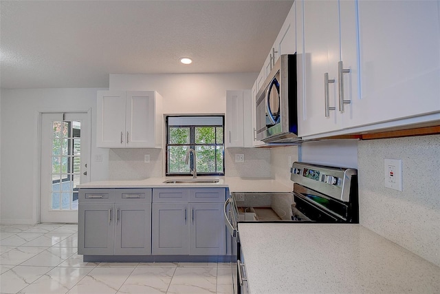 kitchen featuring sink, backsplash, a wealth of natural light, and appliances with stainless steel finishes