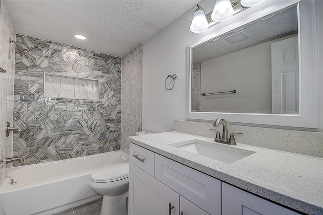 full bathroom featuring tiled shower / bath combo, vanity, a textured ceiling, tile patterned floors, and toilet