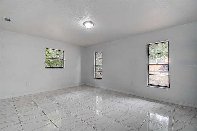 unfurnished room featuring a textured ceiling