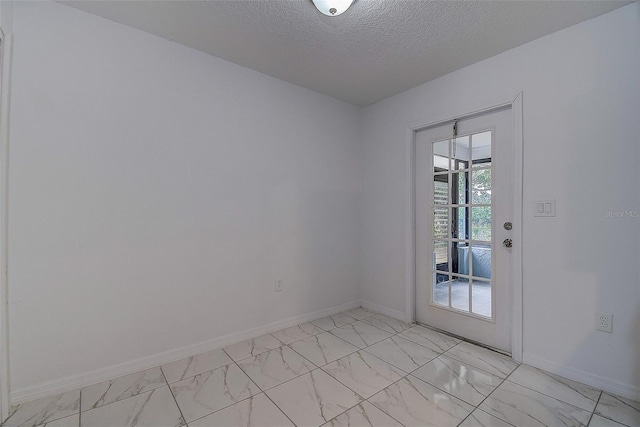 unfurnished room with a textured ceiling