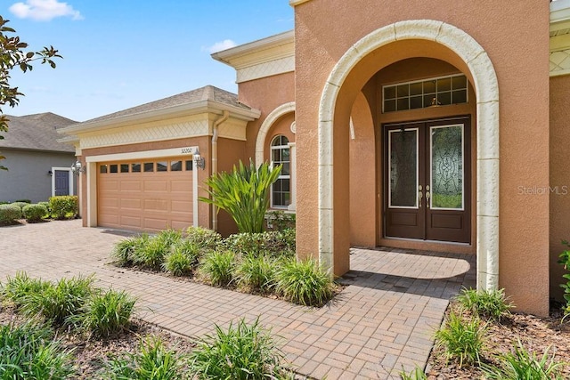 entrance to property featuring a garage and french doors