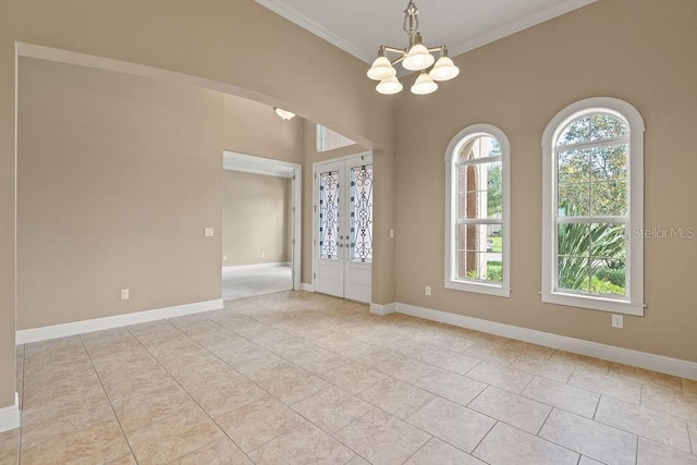 entryway with an inviting chandelier, french doors, light tile patterned flooring, and crown molding