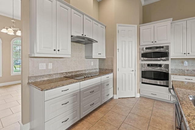 kitchen with white cabinets, ornamental molding, light tile patterned floors, and light stone countertops