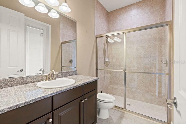 bathroom featuring tile patterned floors, an enclosed shower, vanity, and toilet