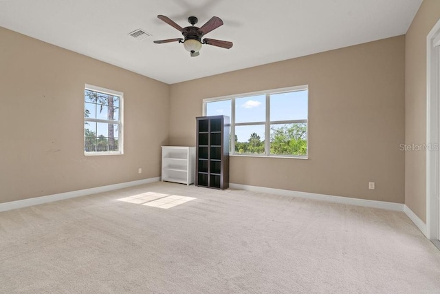 empty room with ceiling fan and light colored carpet