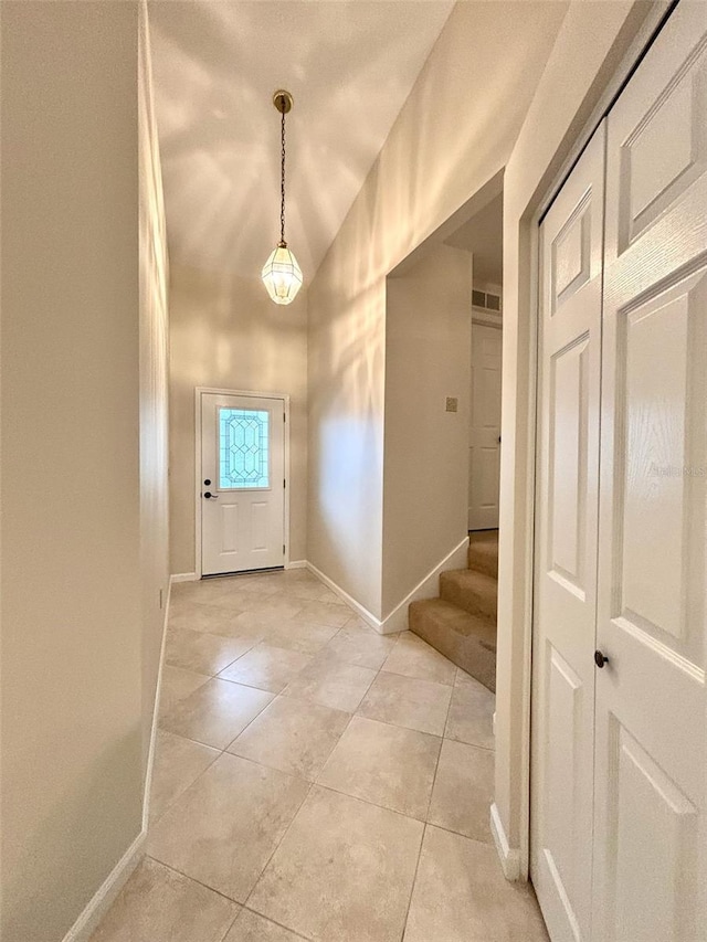 entrance foyer with light tile patterned floors and vaulted ceiling