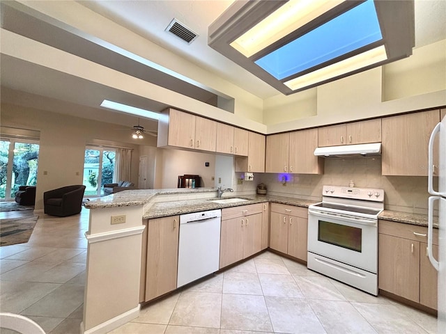 kitchen featuring light brown cabinets, kitchen peninsula, sink, and white appliances