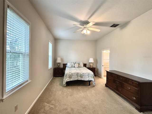 bedroom featuring ceiling fan, ensuite bath, and light carpet