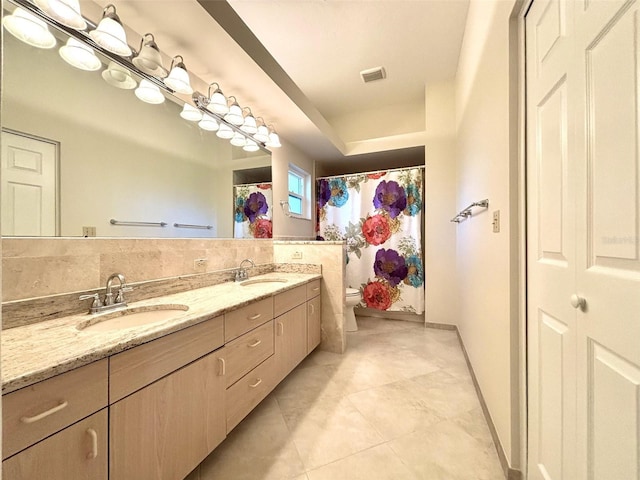 bathroom with toilet, tile patterned floors, and vanity