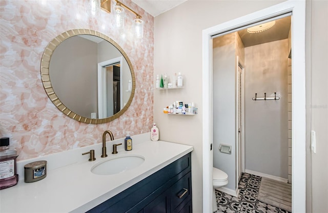 bathroom featuring toilet, tile patterned flooring, and vanity