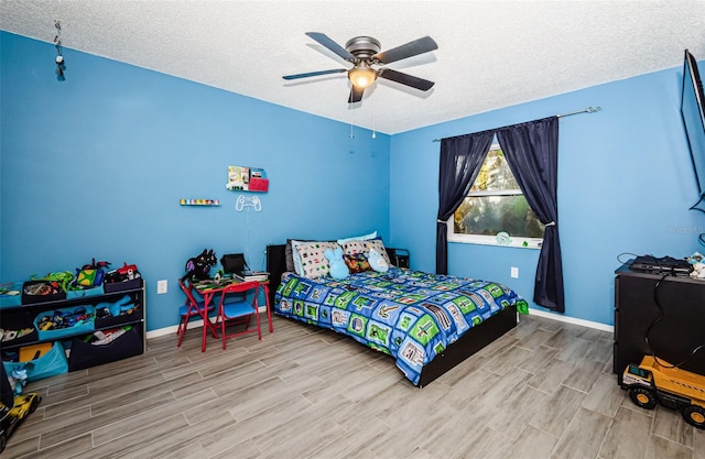 bedroom with ceiling fan and a textured ceiling