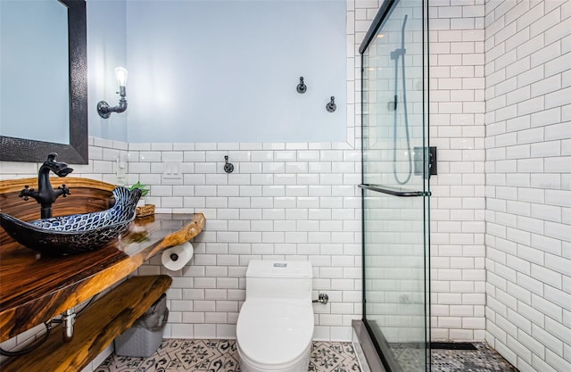 bathroom featuring sink, tile patterned floors, toilet, and a shower with door