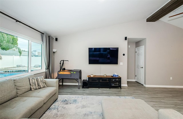 living room with light wood-type flooring and vaulted ceiling with beams