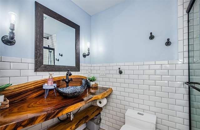 bathroom featuring tile walls, sink, toilet, and walk in shower