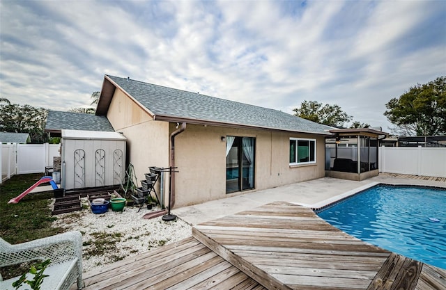 back of property featuring a pool side deck