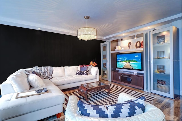 living room featuring a notable chandelier, built in shelves, and hardwood / wood-style flooring