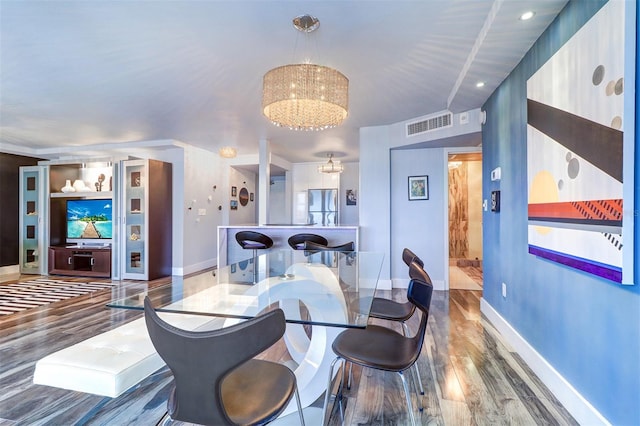 dining area featuring hardwood / wood-style floors and a notable chandelier