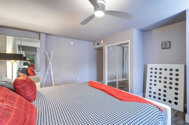 bedroom featuring hardwood / wood-style flooring, ceiling fan, and a closet