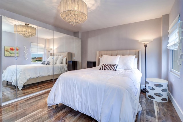 bedroom with a notable chandelier and hardwood / wood-style flooring