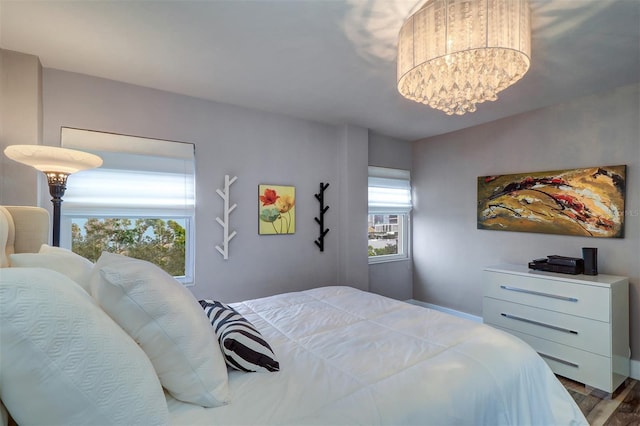 bedroom with hardwood / wood-style floors and a notable chandelier