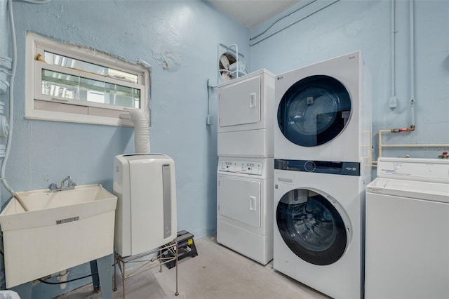 laundry room featuring washer and dryer, stacked washer and clothes dryer, and sink