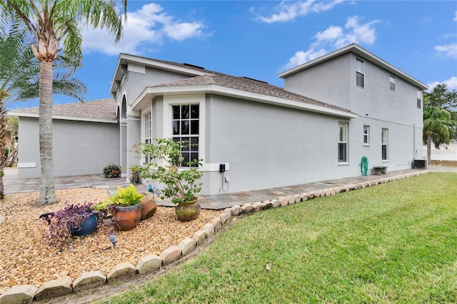 view of side of property with cooling unit and a yard