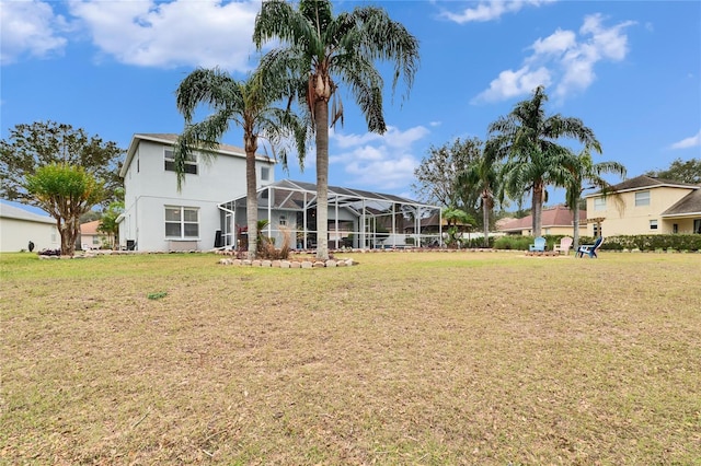 rear view of property with glass enclosure and a lawn