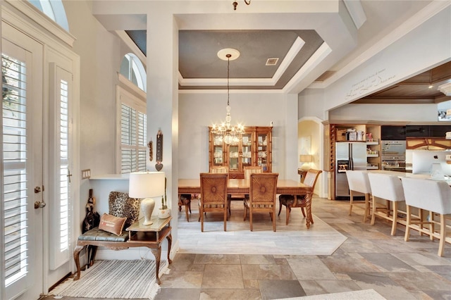 dining space featuring a raised ceiling and a notable chandelier