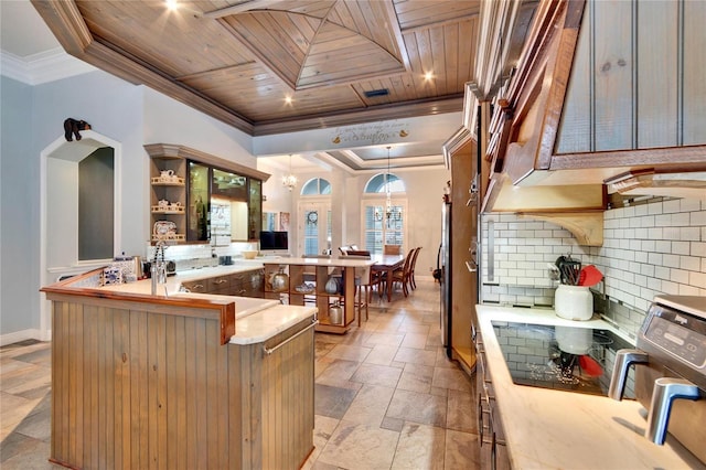 kitchen with a notable chandelier, kitchen peninsula, hanging light fixtures, wood ceiling, and ornamental molding