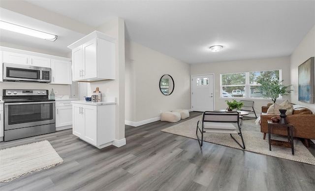 kitchen with white cabinetry, appliances with stainless steel finishes, and dark hardwood / wood-style flooring