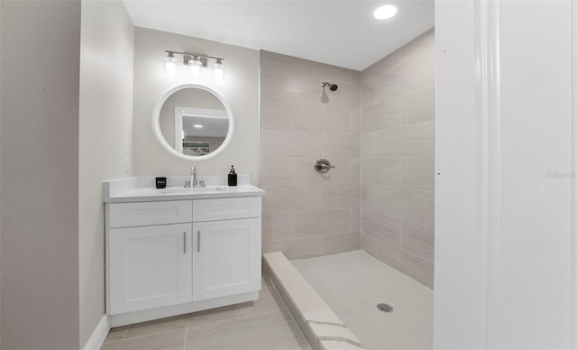 bathroom with vanity and a tile shower