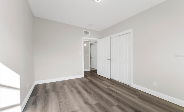 unfurnished bedroom with hardwood / wood-style flooring and a closet