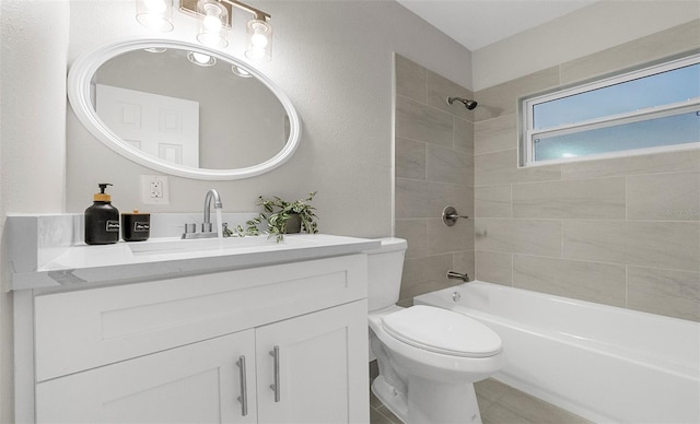 full bathroom featuring vanity, tiled shower / bath combo, tile patterned floors, and toilet