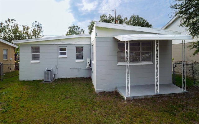 rear view of house featuring a yard and central AC