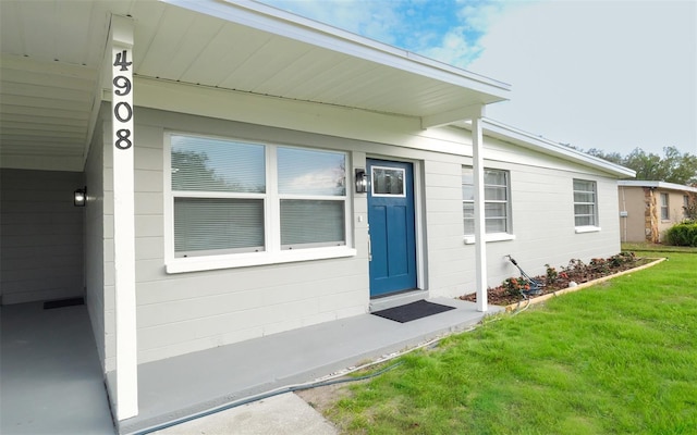 view of exterior entry with a lawn