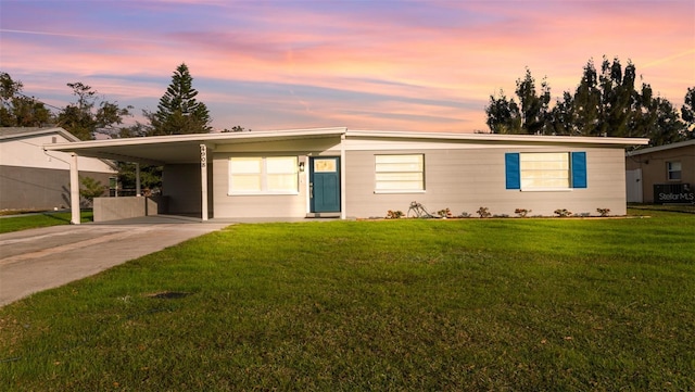 view of front of home with a yard, a carport, and central air condition unit