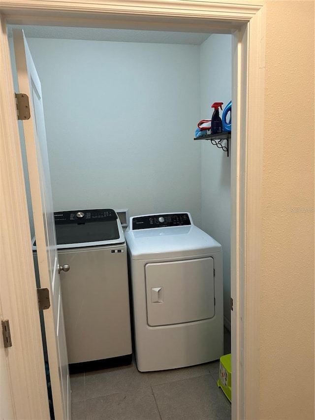 laundry room featuring light tile patterned flooring and washing machine and dryer