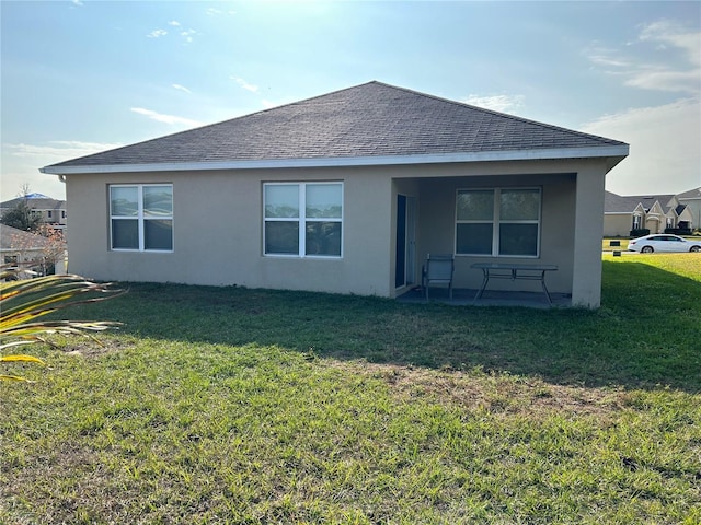 back of property featuring a lawn and a patio