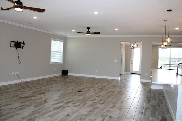 unfurnished living room featuring ornamental molding, ceiling fan, and light wood-type flooring