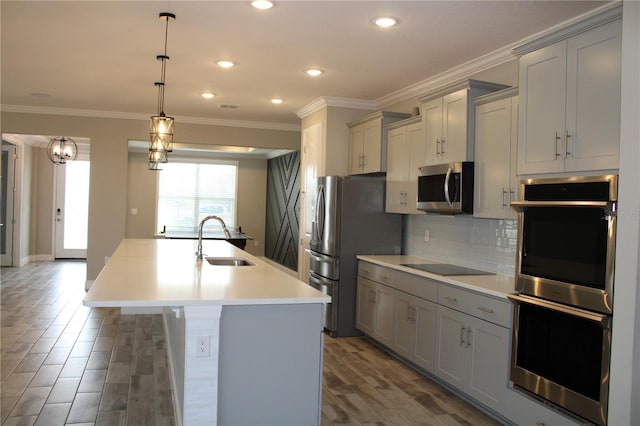 kitchen featuring a center island with sink, appliances with stainless steel finishes, gray cabinetry, and sink