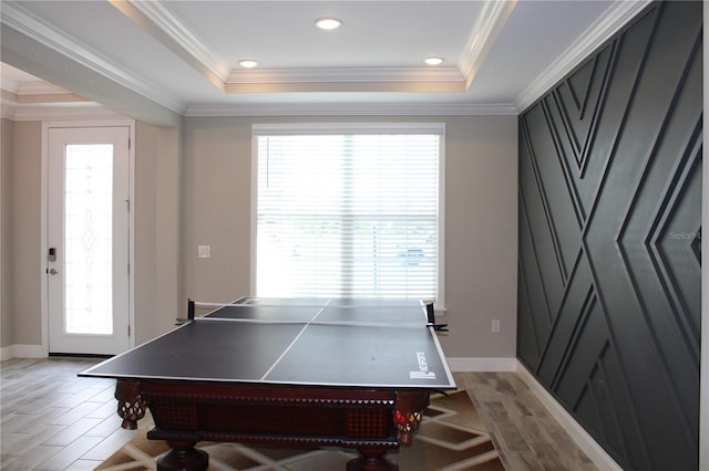 game room featuring light hardwood / wood-style floors, a raised ceiling, and a healthy amount of sunlight