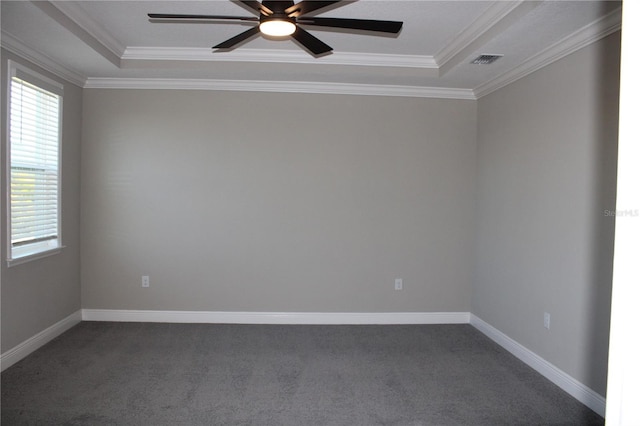 carpeted empty room with ceiling fan, crown molding, and a tray ceiling