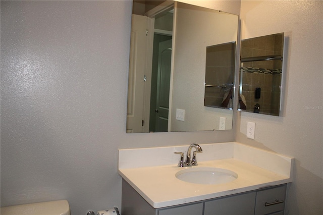 bathroom with toilet, an enclosed shower, and vanity