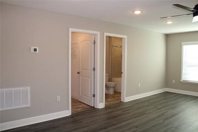 unfurnished room with ceiling fan and dark wood-type flooring