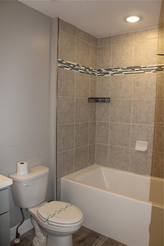 full bathroom featuring toilet, hardwood / wood-style flooring, tiled shower / bath, and vanity