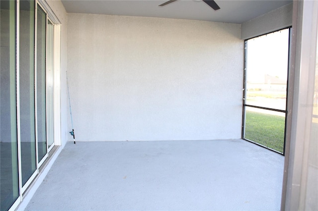 unfurnished sunroom featuring ceiling fan