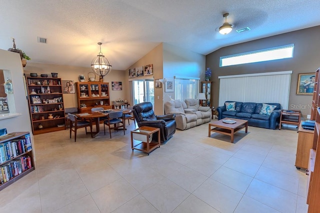 living room with vaulted ceiling, light tile patterned floors, a textured ceiling, and an inviting chandelier