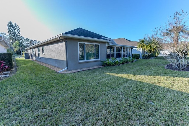 view of home's exterior with cooling unit, a yard, and a sunroom